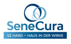 Moderner Wohnkomplex mit mehreren Etagen, großen Fensterfronten und gepflegten Außenanlagen, umgeben von parkenden Autos.