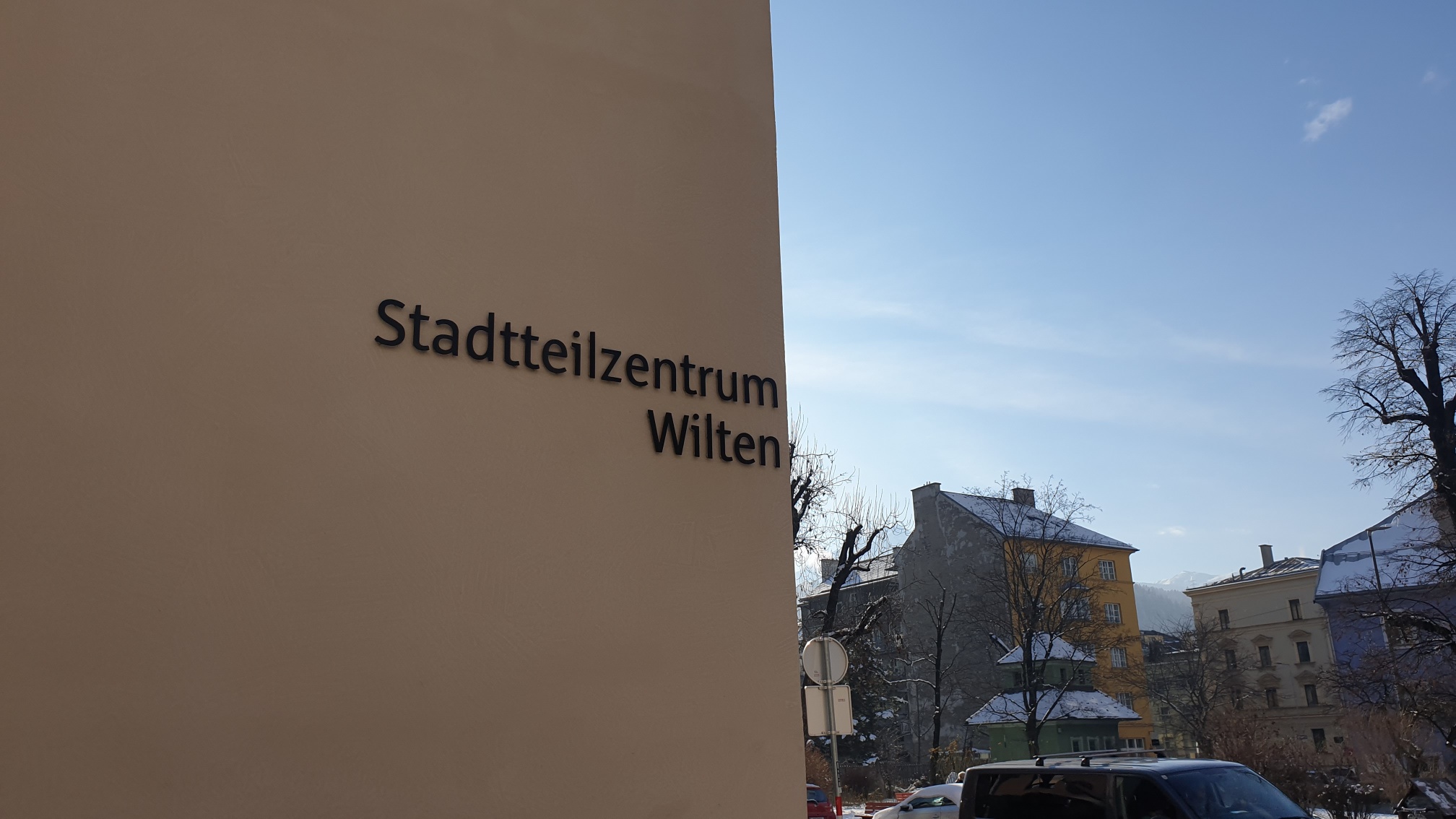 Sicht auf das Stadtteilzentrum Wilten mit Gebäuden und einem wolkenfreien Himmel im Hintergrund.